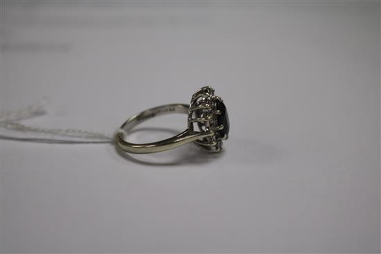 A 9ct white gold, sapphire and diamond oval cluster ring, size L.